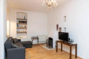 a living room with a couch and a television at Opera House 2BR Apt with Tbilisi Charm - By Wehost in Tbilisi City