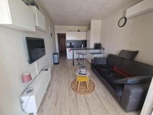 a living room with a black couch and a table at Plage à pieds in Théoule-sur-Mer