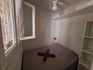 a cross sitting on a bed in a room with a window at Plage à pieds in Théoule-sur-Mer