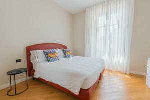 a bedroom with a bed with white sheets and a window at R Azalea House in Como