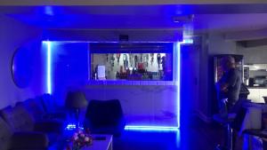 a man standing in a living room with blue lights at North Ocean Hotel in Blackpool
