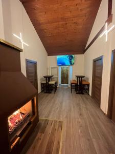 a living room with a fireplace and tables and chairs at Apartmani & Auto kamp GAJ in Gacko