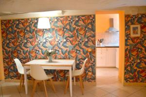 a dining room with a table and chairs with a floral wallpaper at Piazza Napoleone Sweet apartment in Lucca +10 photos