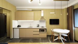 cocina con mesa, fregadero y mesa en Comfortable Studio In Tbilisi, en Tiflis 18 fotos más