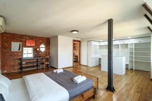 Un dormitorio con una cama y una pared de ladrillo. en Vintage Mezzanine Apt in City Center - By Wehost, en Tiflis