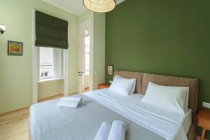a bedroom with a large bed with two towels on it at Stylish 2BR Apt in Tbilisi - By Wehost in Tbilisi City