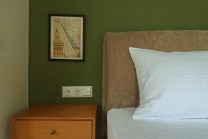 a bedroom with a bed and a nightstand with a picture on the wall at Stylish 2BR Apt in Tbilisi - By Wehost in Tbilisi City