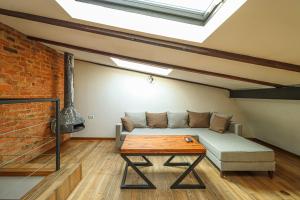 una sala de estar con un sofá y una mesa en Vintage Mezzanine Apt in City Center - By Wehost, en Tiflis