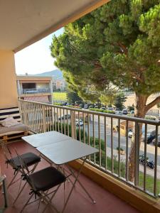 ル・ラヴァンドゥーにあるAppartement L'Anjaure - Lavandouの木のあるバルコニー(テーブル、椅子付)