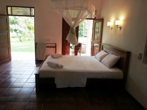 a bedroom with a bed with two towels on it at Hettimulla River House in Bentota