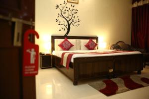 een slaapkamer met een bed met een boom aan de muur bij Hotel the diamond Ring in Chandīgarh +1 foto