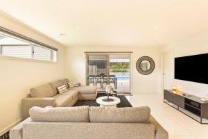 Family w Large Pool & Game Garage Wlk to Beach في كاوز: غرفة معيشة مع أريكة وتلفزيون