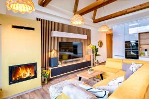 a living room with a couch and a fireplace at TATRYSTAY Cactus Premium Villa High Tatras private Wellness in Stará Lesná +35 photos