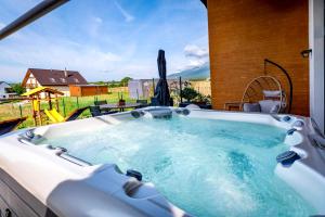 a jacuzzi tub with a view of a yard at TATRYSTAY Cactus Premium Villa High Tatras private Wellness in Stará Lesná