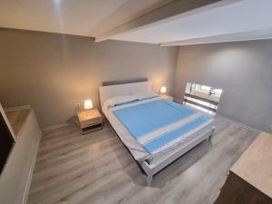 1 dormitorio con 1 cama grande con sábanas azules y ventana en L'altra Vinedda - Proppro SRL - Milazzo, en Milazzo 8 fotos más