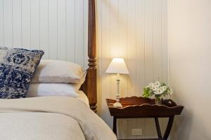 a bedroom with a bed and a table with a lamp at The Ancient Mariner Retreat in Cape Woolamai