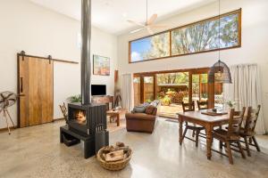 a living room with a table and a fireplace at The Ancient Mariner Retreat in Cape Woolamai