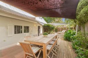 a wooden table and chairs on a patio at Kilara Cottage 3-Bed 2-Bath in Cowes