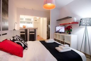 a bedroom with a large white bed and a kitchen at Apartment Madera in Belgrade