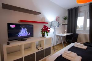 a room with a tv and a bed and a desk at Apartment Madera in Belgrade