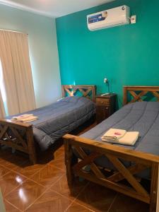 two beds in a room with green walls at DEPARTAMENTO CAROLA in San Juan