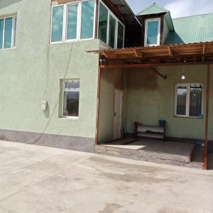 ChayekJumgal guest house的前面有长凳的绿色房子