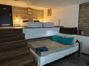 a bed with blue pillows on it in a room at Mountain Cricket Chalets and Apartments Gudauri in Gudauri