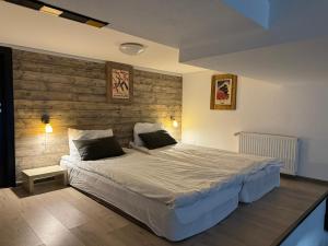 a bedroom with a large bed and a wooden wall at Mountain Cricket Chalets and Apartments Gudauri in Gudauri