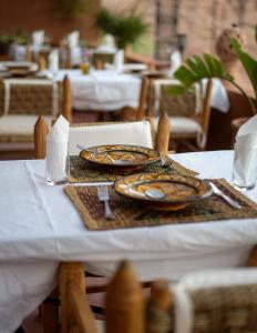 a table with a white table cloth with plates on it at Riad Rihana Dades in Boumalne