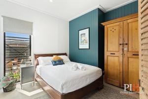 a bedroom with a bed with a blue wall at Charming 4 BR Cottage Retreat in Newhaven