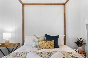 a bedroom with a bed with a wooden headboard at Charming 4 BR Cottage Retreat in Newhaven +22 photos