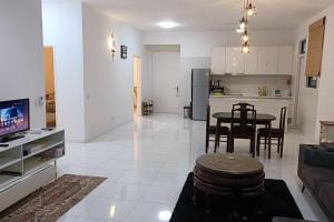 Il comprend un grand salon avec une table et une cuisine. dans l'établissement Sky Loft 4 Guests Balcony Nflix Disney B30A, à Johor Bahru