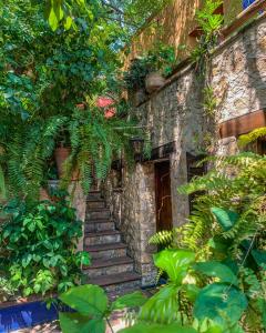 a stone building with stairs leading up to a door at La Casa del Guamúchil in Tequesquitengo