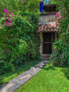 a stone building with a door and some flowers at La Casa del Guamúchil in Tequesquitengo