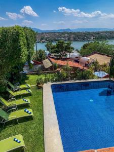 a swimming pool with lounge chairs and a view of the water at La Casa del Guamúchil in Tequesquitengo