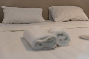 two rolls of towels sitting on a bed at Cozy Studio Apartment For 3 with a pool in Batumi