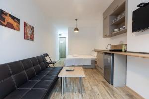 una sala de estar con un sofá y una mesa en Cozy Studio Apartment For 3 with a pool, en Batumi