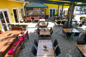 eine Außenterrasse mit Tischen und Stühlen und ein Restaurant in der Unterkunft Tuniberg Restaurant Hotel in Freiburg im Breisgau