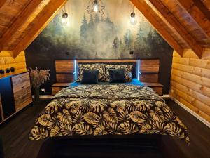 a bedroom with a bed with a painting on the wall at Rogate Chatki in Lutowiska
