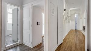 a hallway with white walls and wood floors at Hostel Casa d'Alagoa in Faro