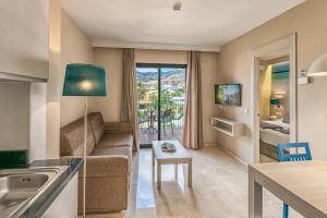 ein Wohnzimmer mit einer Couch und einem Tisch in der Unterkunft Benalmadena Palace Spa in Benalmádena