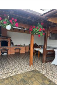 a patio with a table and flowers in a building at Casă de Vacanță Raul in Gura Rîului