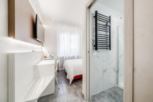 a white room with a bed and a bathroom at Room Milano Navigli in Milan +80 photos