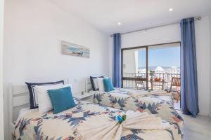 una camera da letto con due letti e una grande finestra di Cruzeiro - Silhueta Citadina a Portimão Altre 92 foto