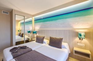 ein Hotelzimmer mit einem Bett und einem großen Spiegel in der Unterkunft Benalmadena Palace Spa in Benalmádena