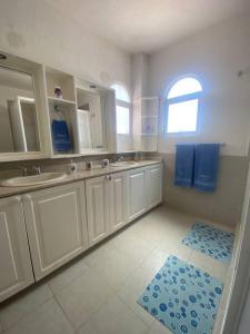 a bathroom with white cabinets and a blue rug at Beautiful house in secure subdivision in Acapulco
