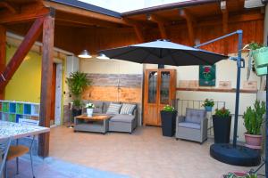 a patio with an umbrella and chairs and a table at Giardino Darianna in Ripacandida