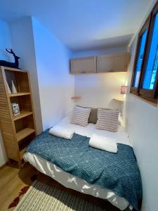 une petite chambre avec un lit avec deux oreillers dans l'établissement Les Chalets du Glacier - Chalet Emma - Chamonix, à Chamonix-Mont-Blanc