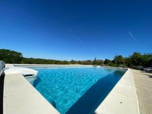 una gran piscina con agua azul en Villa coucher de soleil, en Pontours 35 fotos más