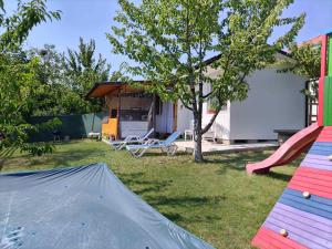 a backyard with a house with a tent and a playground at Къща Виктория in Banya